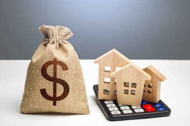 A bag of money sitting next to some houses.